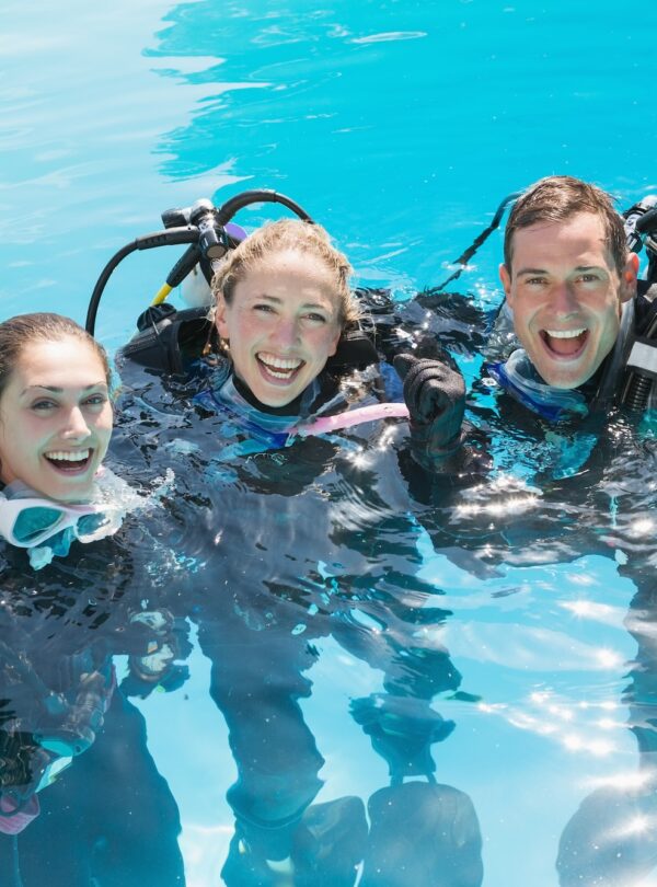 smiling-friends-scuba-training-swimming-pool-cheering-camera copia
