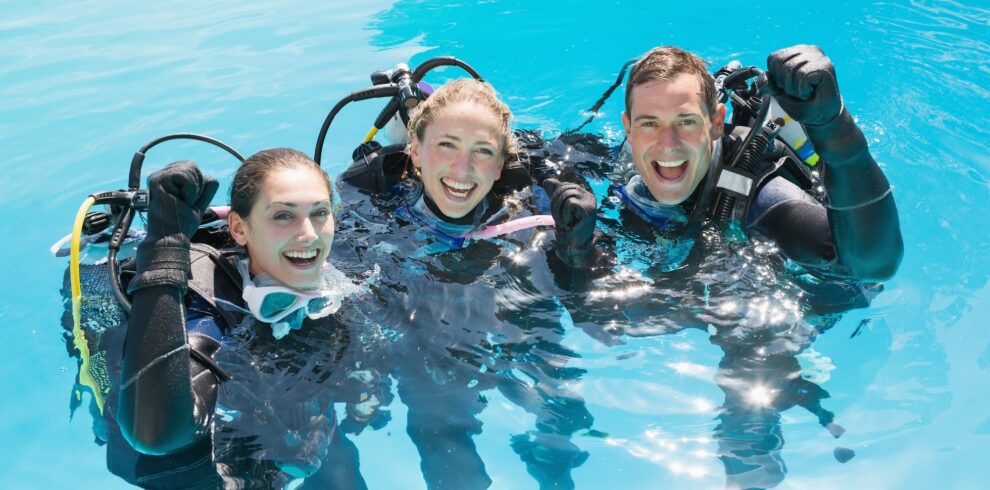 smiling-friends-scuba-training-swimming-pool-cheering-camera copia